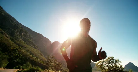 Runner jogging slow motion in mountains against bright sky Stock Footage 48363988