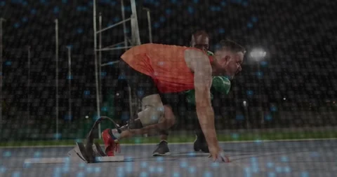 Runner kneeling testing running blade coach steadying behind particles rising Stock Footage 333901352