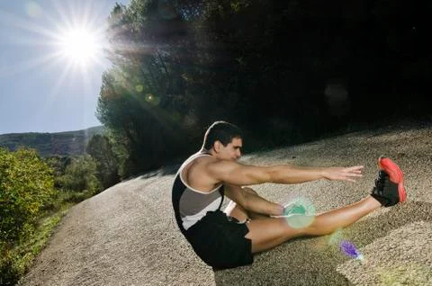 Runner legs with sun light in forest road Stock Photos