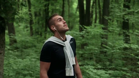 Runner looking at his smartwatch while running in the forest Stock Footage 75542881