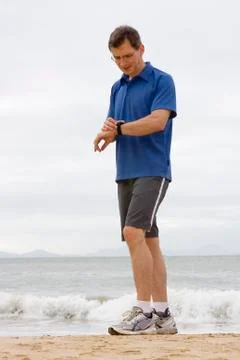 Runner looking at stop watch Stock Photos