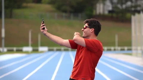 Runner Making Video Call with Smartphone Before Training on Athletic Track Stock Footage 277500870