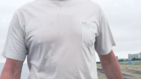 Runner man on calm and cloudy beach finish running. Closeup tilting shot Stock Footage 82410830