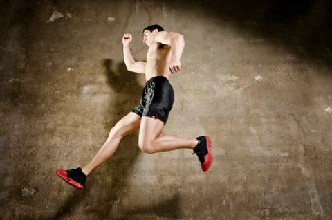 Runner man jumping with dirty wall background Stock Photos