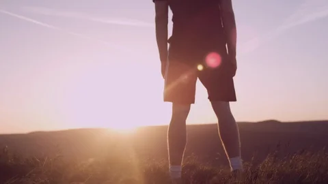 Runner man looking out over the valley at sunset, epic windy day Stock Footage 85659433