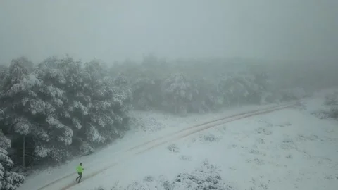 Runner man running at the forest full of snow. Aerial view Stock Footage 146551237