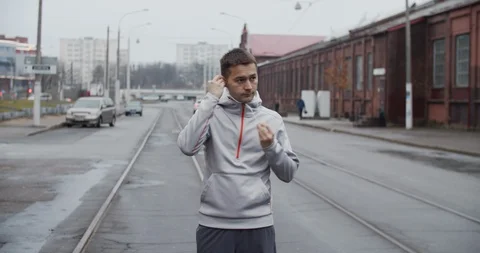 Runner man running on the road in the city, listening to music on headphones. Stockbeeldmateriaal 121544217