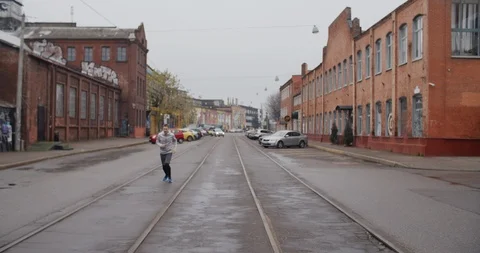 Runner man running on the road in the city, listening to music on headphones. 库存影片 121545470