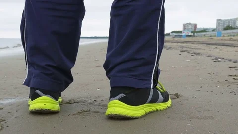 Runner man start jogging along the sea shore. Closeup view on shoes Stock Footage 82480622
