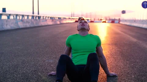 Runner man stretching and taking rest on road. Handsome Caucasian male fitnes Stock Footage 67368382