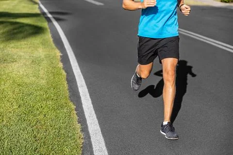 Runner man training marathon run jogging in running shoes on city road street Stock Photos