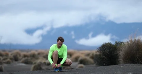 Runner man tying running shoes and runs on trail outdoors Stock Footage 117406538