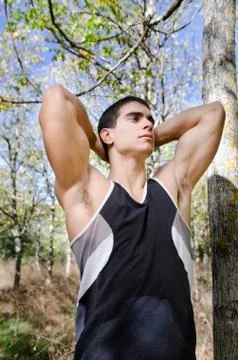 Runner man warming arms into the trees Stock Photos