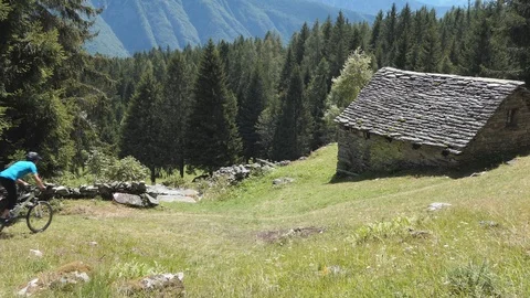 Runner on a mountain path and chalet Stock-Footage 114174484