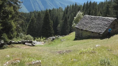 Runner on a mountain path and hut Stock-Footage 114174706