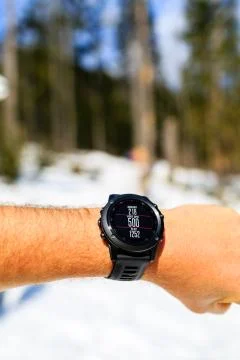 Runner on mountain trail looking at stopwatch, activity tracker Foto stock