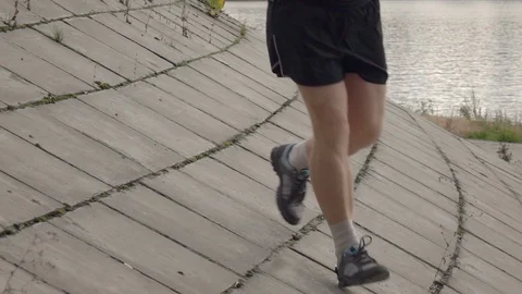 Runner moving down from flagging downhill in slow motion. Close up legs shot. 動画素材 122154337