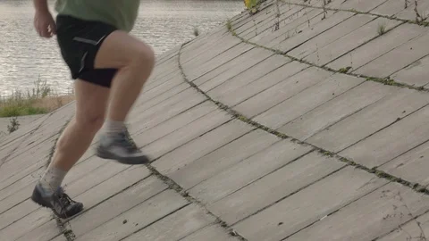 Runner moving up on flagging downhill in slow motion. Close up legs shot. Vidéo 122154295