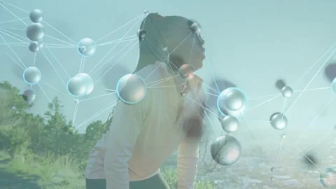 Runner pausing after run on hill, tuning earbud for health while node overlay Video stock 333526495