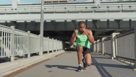 Runner performing duck walk warm up exercise Stock Footage 117065192