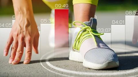 Runner prepares to start race on track with timing data displayed Stock Photos