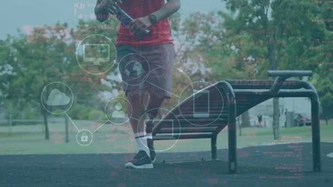 Runner with prosthetic running to bench, checking fitness tracker, placing Stock Footage 333539846