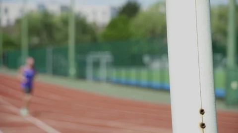 Runner in purple vest jogging on track. Stock-Footage 93202994