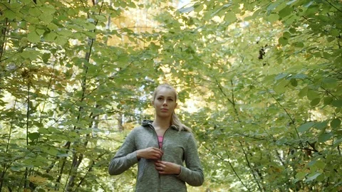 The runner puts on the hood and proceeds to run. the girl buttoned up on the Stock Footage 81710372