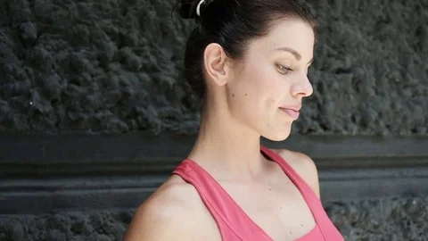 Runner readies herself for a run by putting earphones in her ears. Video stock 77956842