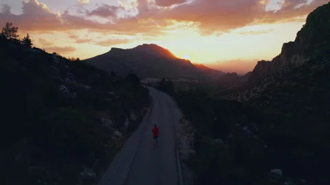 Runner in Red Shirt on Mountain Road at Sunset Aerial Stock Footage 331714676