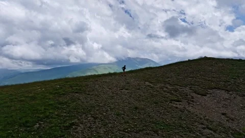 Runner rugged mountain terrain. Drone video of a man running along a mountain Stock Footage 333042161