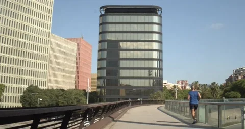 Runner running between the skyscrapers of a city Stock Footage 131261048