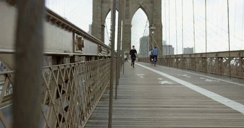 Runner Running Towards Camera On Iconic Beautiful Brooklyn Bridge With Impres 库存影片 112773896