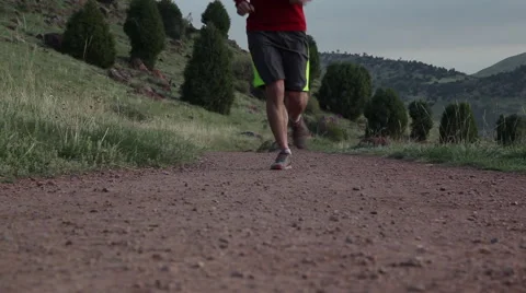 Runner runs past camera on a red dirt trail Stock Footage 51333041