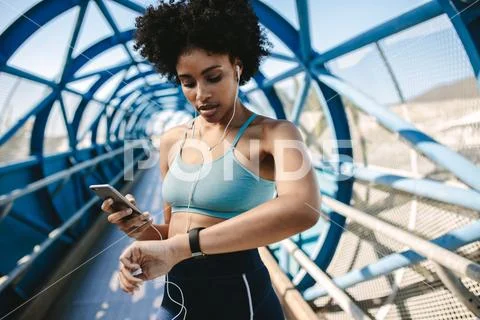 Runner setting up her smart watch for run Stock Photos