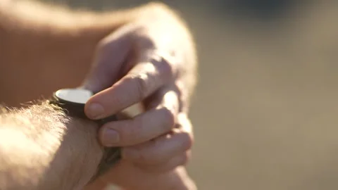 Runner setting his smart watch to start his run in golden light Stock Footage 340219726