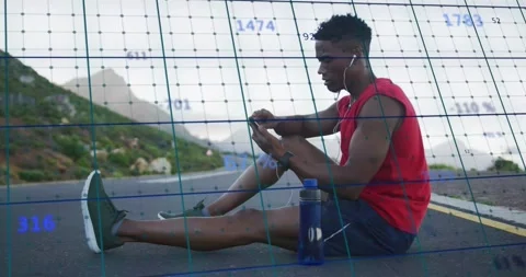 Runner sitting on mountain pass tapping phone after run tracking fitness with Stock Footage 331833565