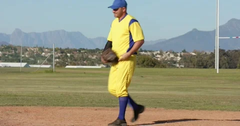 Runner sprinting, male first baseman catching baseball on field with Diverse Stock Footage 340986268