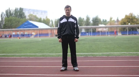 Runner in the stadium is on track and looking at the camera Stock Footage 55767784