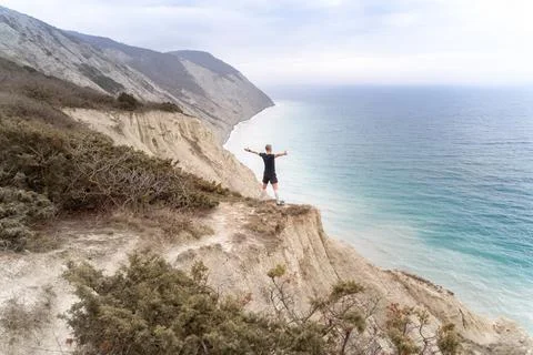 Runner standing on mountains and open arms Stock Photos