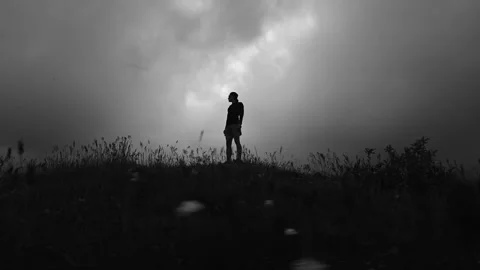 Runner stands on a field in thick grass after an intense workout. Regular Stock-Footage 329223324