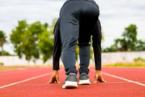 Runner on starting line of track, ready to sprint, outdoor athletics compet.. Stock Photos