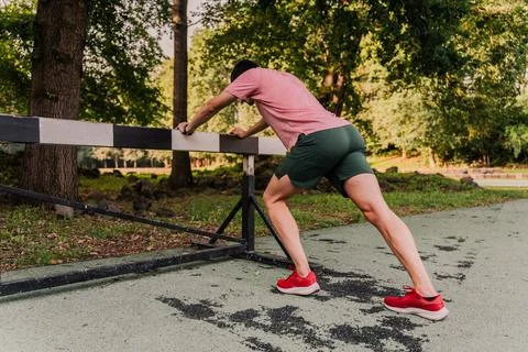Runner stretching with the help of a strap after training Stock Photos
