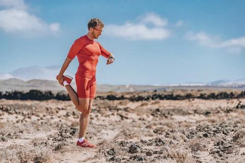 Runner stretching legs using smartwatch for trail run. Athlete checking smart 写真素材