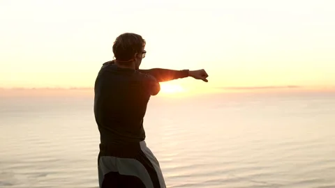 Runner stretching overlooking the ocean in golden light with light leaks 4k Stock Footage 338228078