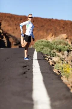 Runner stretching on road Stock Photos
