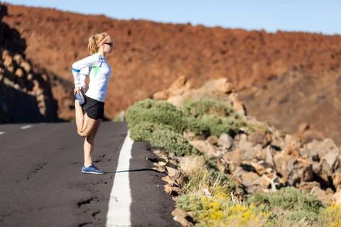 Runner stretching on road Stock Photos