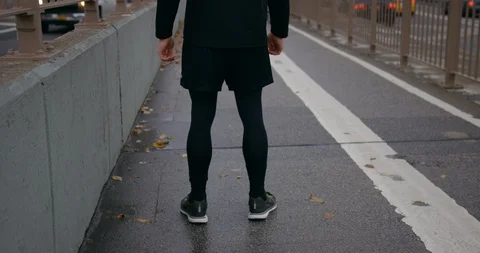 Runner Stretching For A Run On Classic New York Road Towards Brooklyn Bridge  Stock Footage 112592970