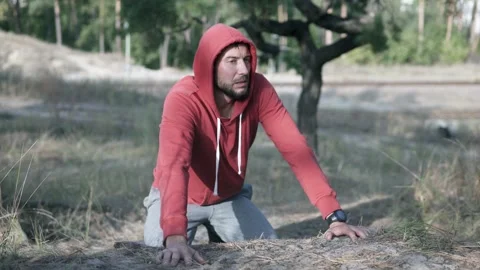 A runner stumbles along a forest trail, showing signs of emotional struggle. Stock Footage 315551994