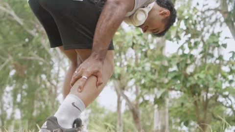 Runner suffering sudden leg cramp during outdoor exercise Video stock 344881788